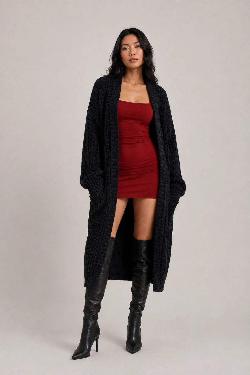 Black cardigan with long sleeves, open front, two side pockets, worn over red dress