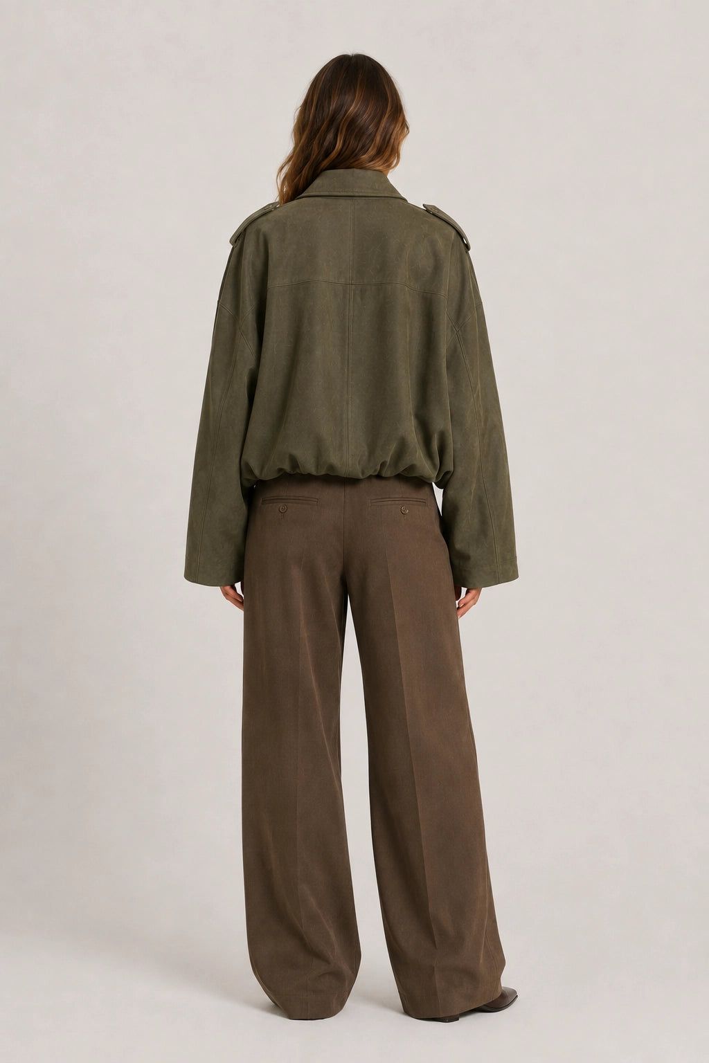 Olive green jacket back view with elastic hem and button front