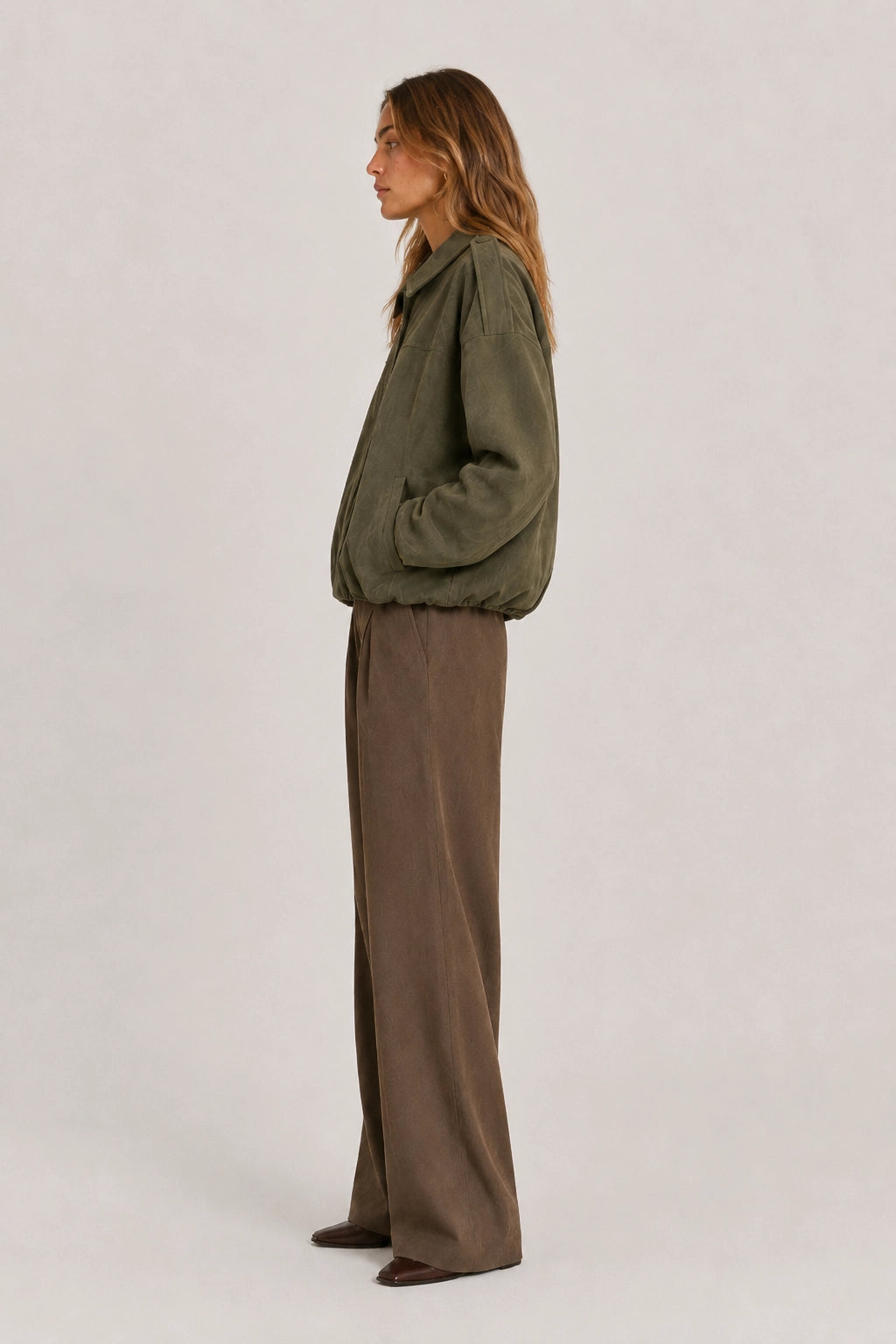Olive green jacket with wide sleeves and elastic cuffs, side view